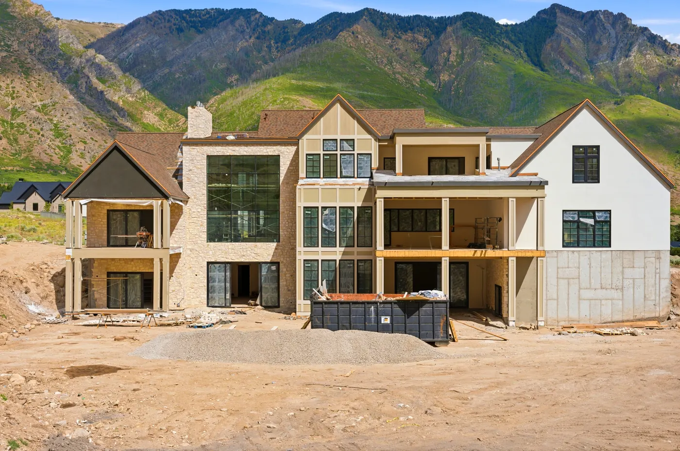 Rear of the home with two-story glass and mountain views
