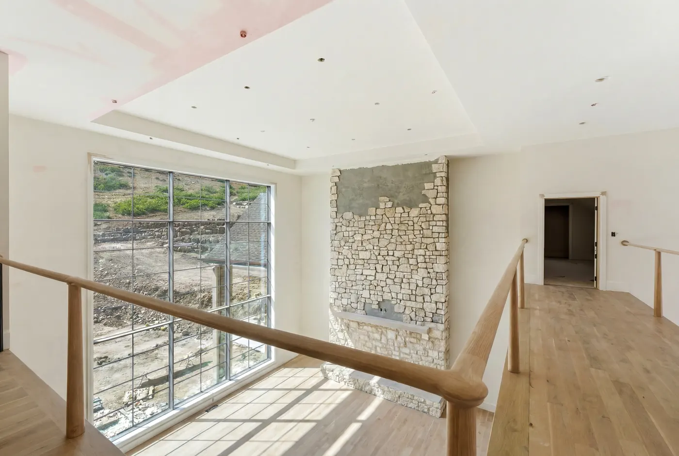 Two-story glass landing with stone wall